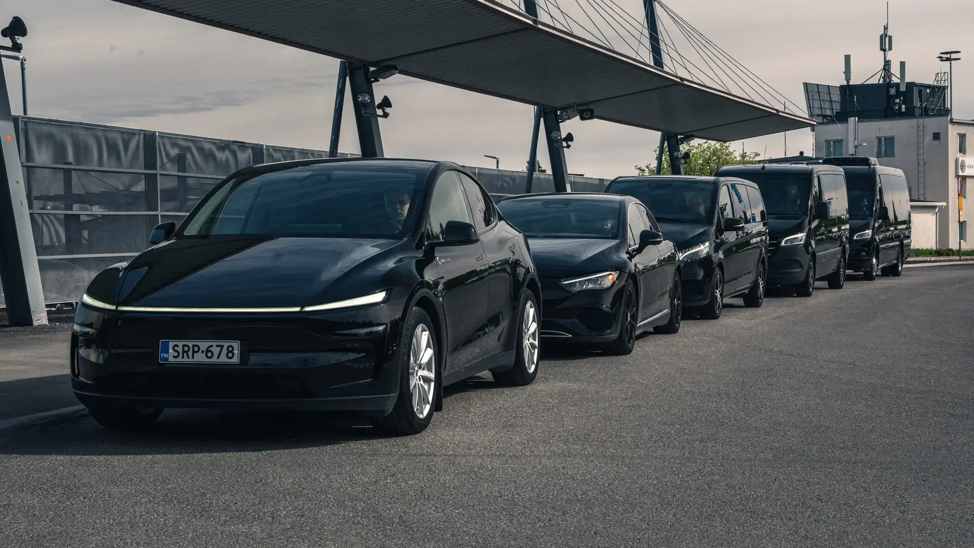 A line of black cars, minivans and Sprinter vans from the Vulpes Aurora family fleet in Rovaniemi, Finland.